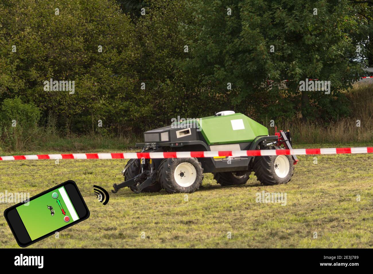Autonomer Traktor auf dem Feld. Holzschild mit Inschrift in deutschen autonomen Traktor. Smart Farming und digitale Transformation in der Landwirtschaft. Stockfoto