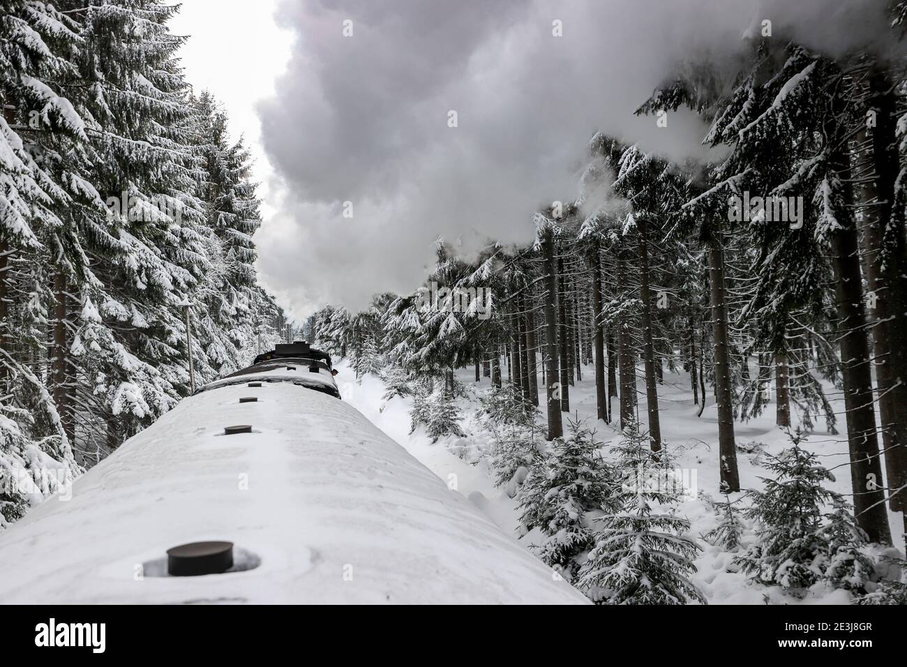 Sehmatal, Deutschland. Januar 2021. Die Fichtelbergbahn dampft durch das verschneite Erzgebirge. Den Passagieren wird derzeit ein wunderbarer Blick auf die schneebedeckte Landschaft geboten. Aber die Züge sind nur spärlich besetzt, genau wie die der anderen Bimmelbahnen in Sachsen. Aufgrund der Einschränkungen von Corona überschreiten die Züge, die hauptsächlich von Touristen genutzt werden, derzeit nicht die Kapazität von 25 Prozent. Quelle: Jan Woitas/dpa-Zentralbild/dpa/Alamy Live News Stockfoto