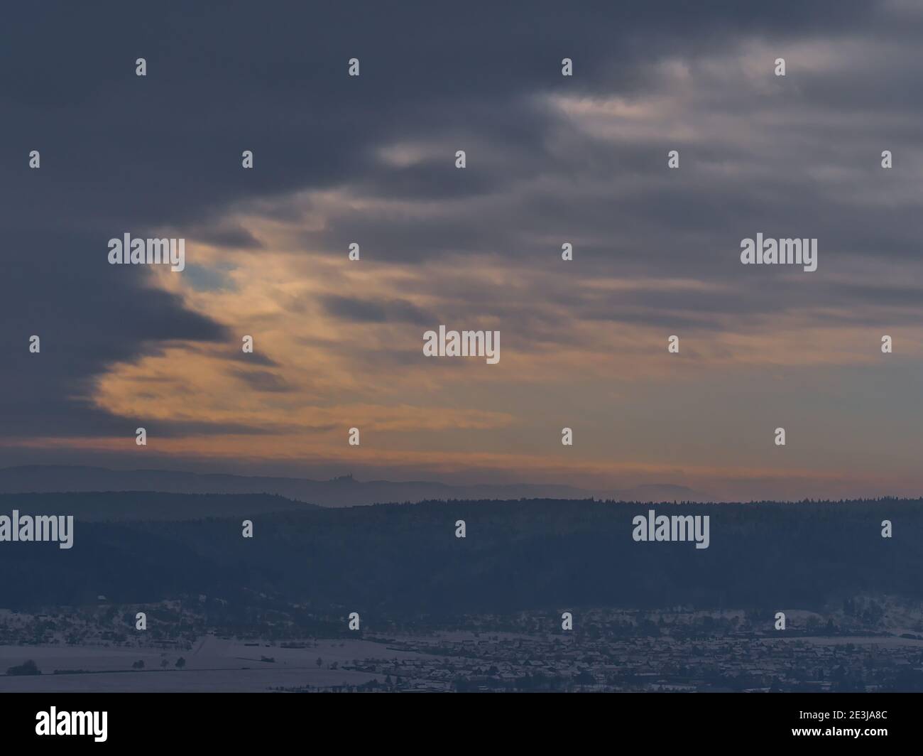 Schöne Luftpanoramablick auf die Ausläufer der Schwäbischen Alb, Deutschland im Winter mit Dorf, schneebedeckten Feldern und Silhouetten der Hohenzollern Burg. Stockfoto