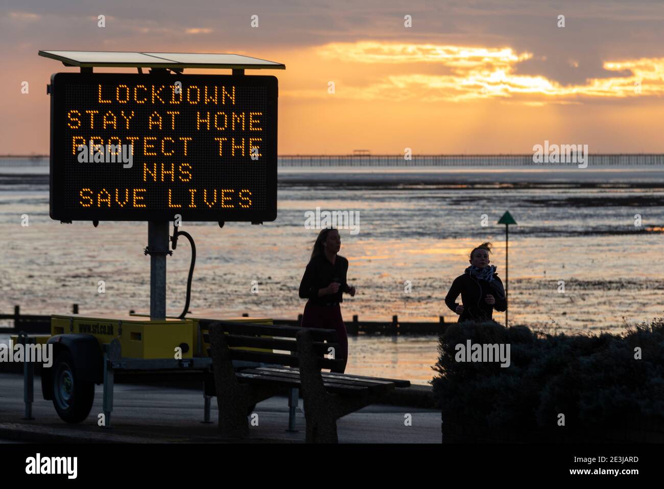 COVID 19, Coronavirus Warnschild auf dem Anflug nach Southend am Meer am frühen Morgen, bevor es voll wird. Jogginghose für den Lauf im Morgengrauen Stockfoto