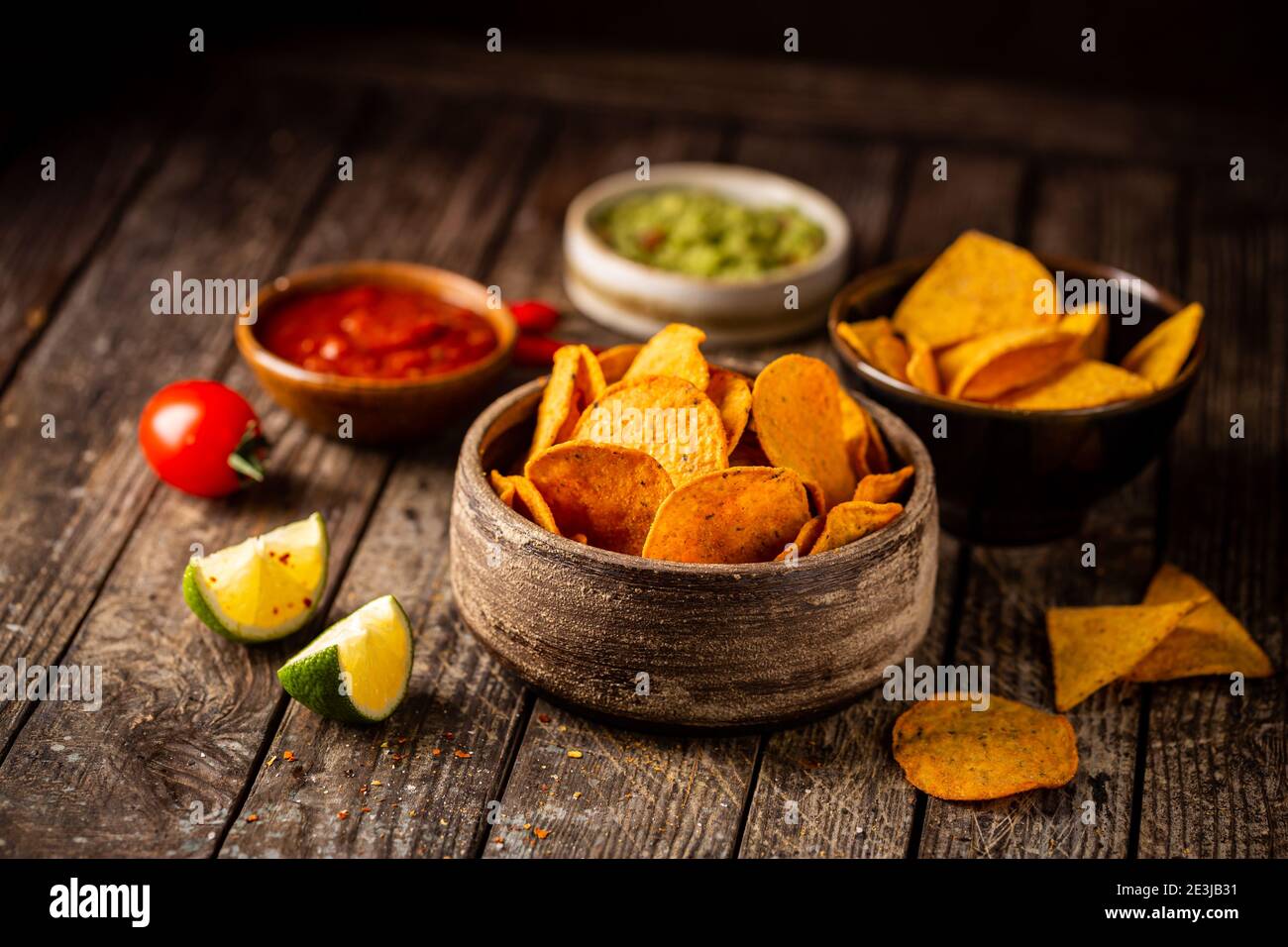 Zwei Biowls gelber Mais Tortilla Nachos Chips mit Salsa Und Guacamole Sauce auf Holzgrund Stockfoto