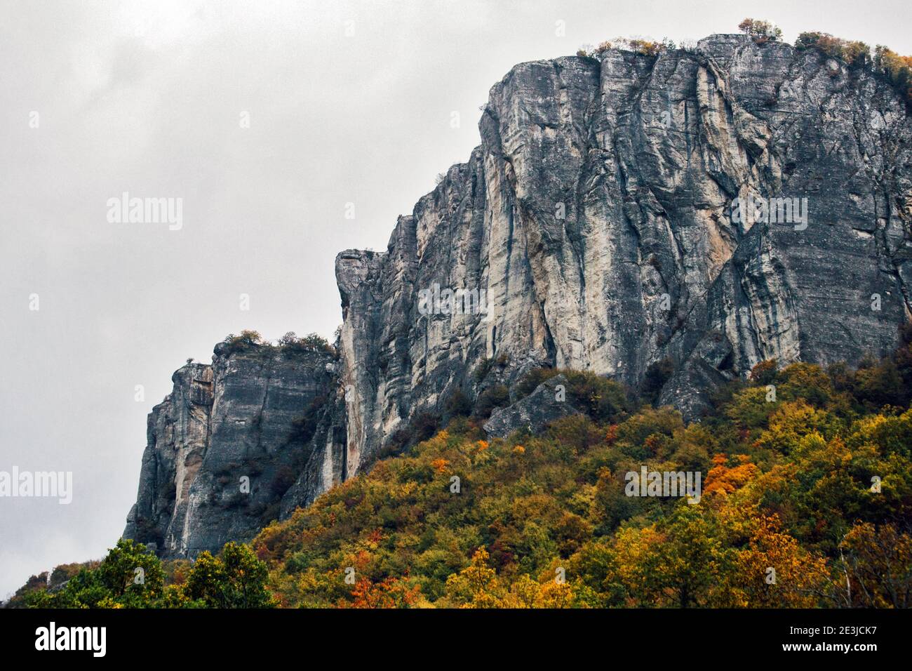 Landschaftlich schöner Blick auf den Felsen zum Klettern gegen einen herbstlichen Laubwald, Pietra Di Bismantova, Reggio Emira, Italien Stockfoto