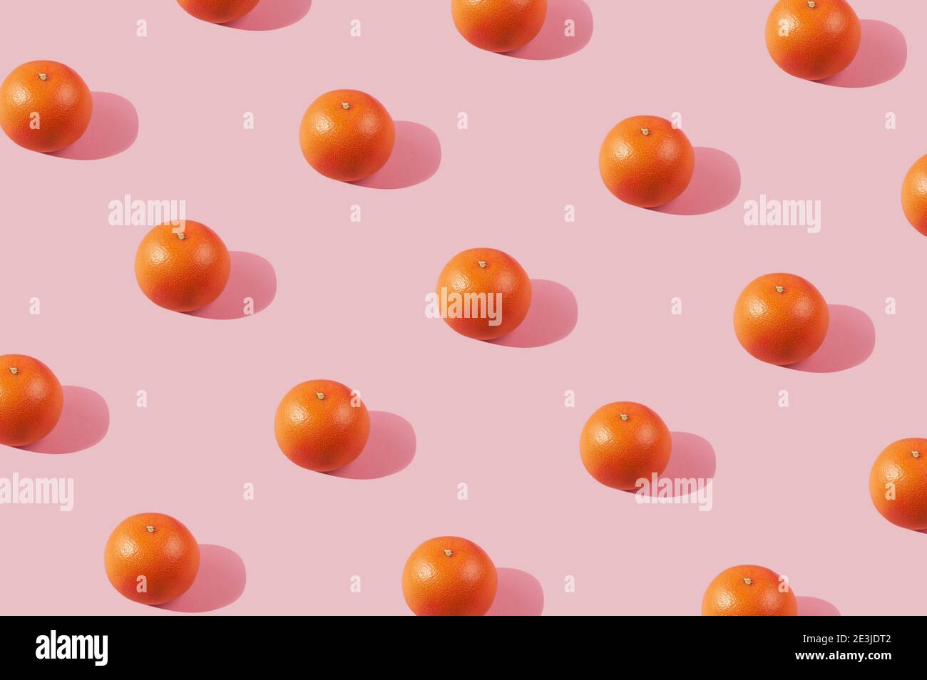Sonnenlicht Sommer Muster mit orangen Grapefruits auf hellrosa Hintergrund. Minimaler Sommer-Konzept.Citrus Früchte Hintergrund. Stockfoto