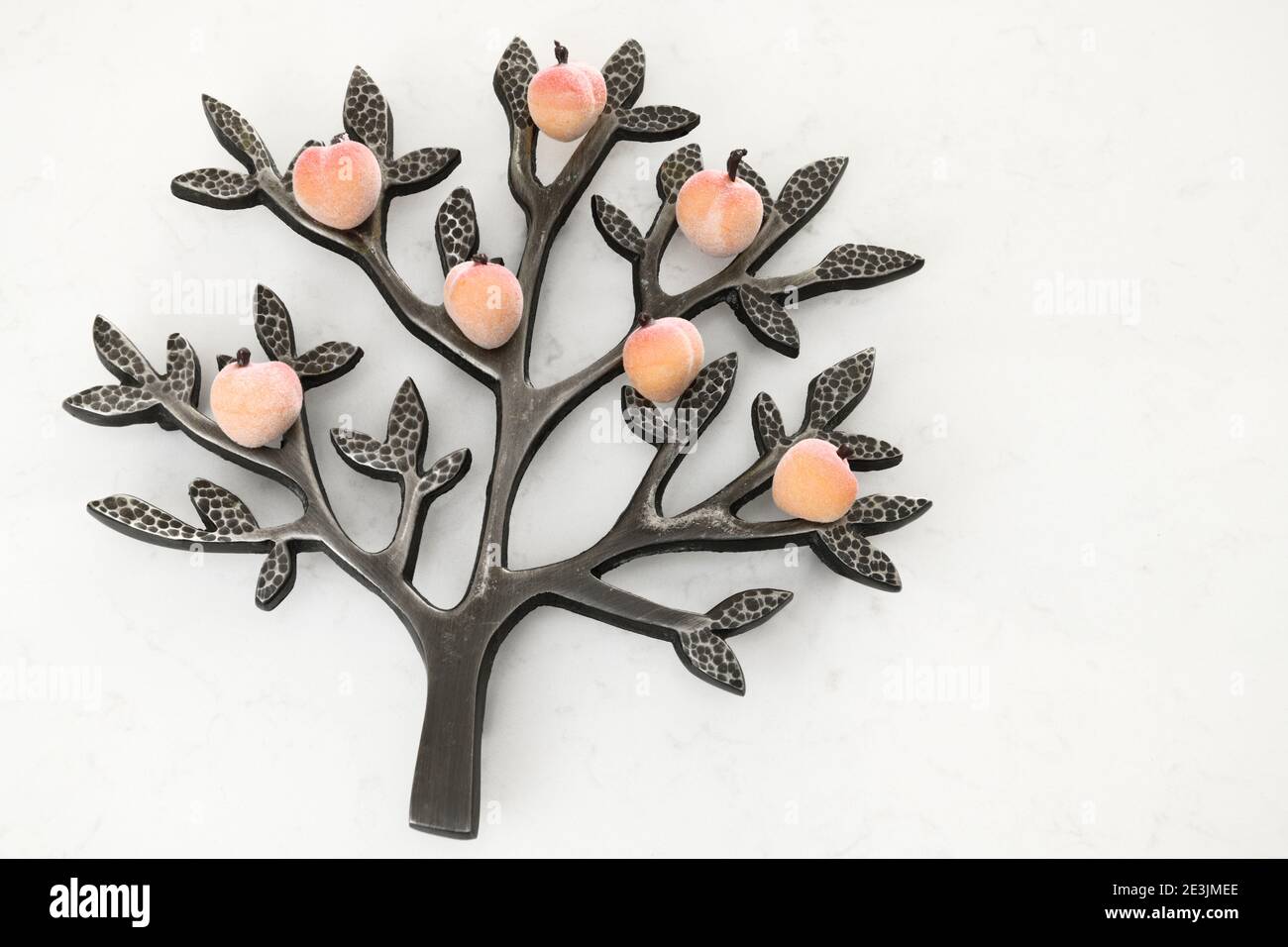 Pfirsichbaum Metallniet auf weißem Granit Stockfoto