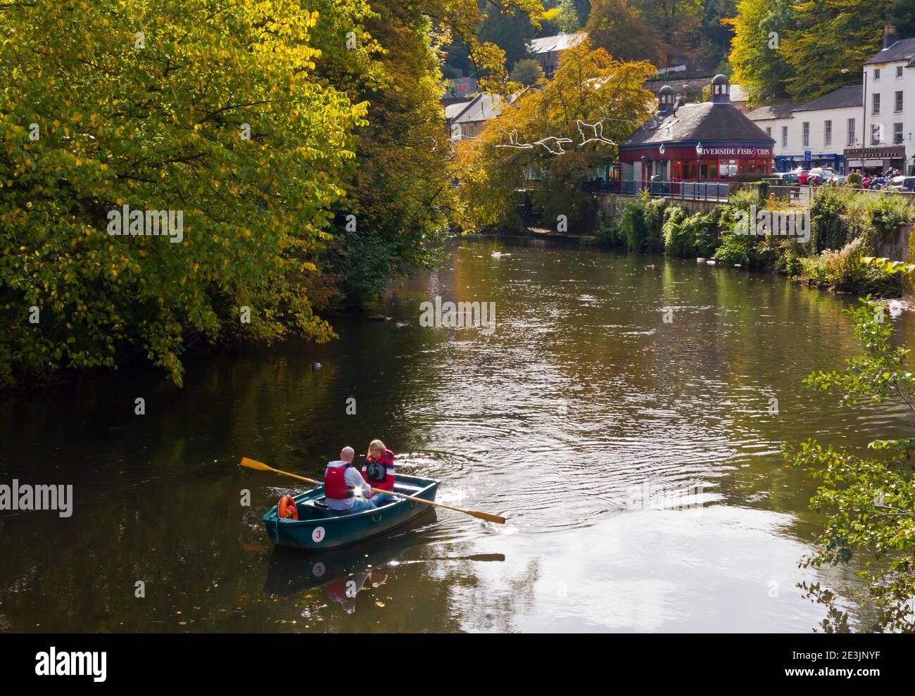 Herbstansicht eines Paares in einem Ruderboot auf dem River Derwent in Matlock Bath ein Dorf in der Derbyshire Dales Gebiet des Peak District England Großbritannien Stockfoto