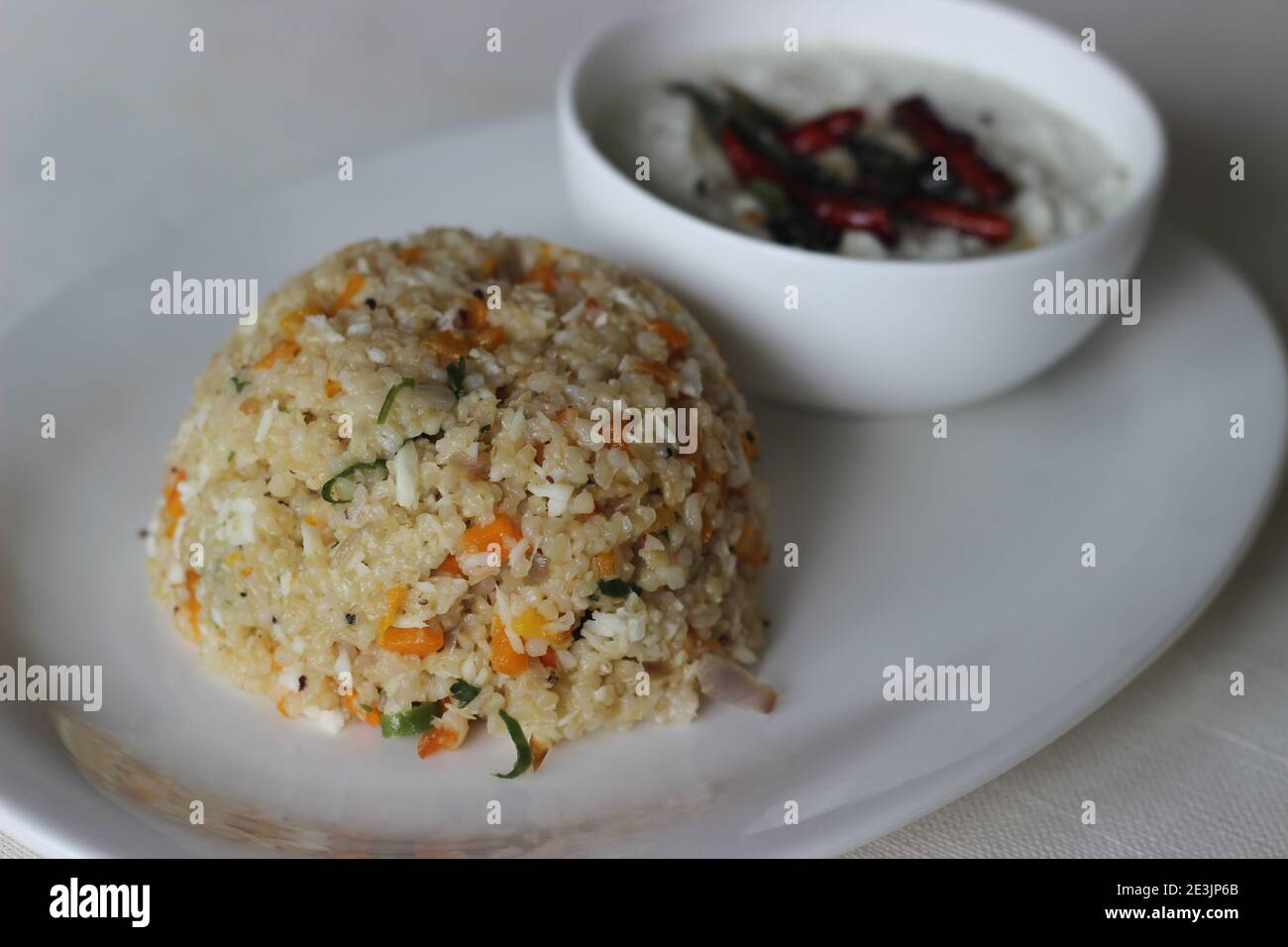 Dalia Upma oder Broken Wheat Upma ist ein südindisches Frühstück mit gebrochenem Weizen, mischen Gemüse und andere grundlegende Temperierung Zutaten serviert mit Stockfoto