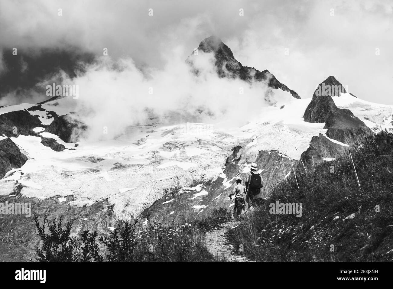 Vater und Sohn wandern im Sommer in den französischen Alpen. Der Aiguille des Glaciers, Berg im Mont Blanc Massiv. Savoie, Frankreich. Schwarzweißfoto Stockfoto