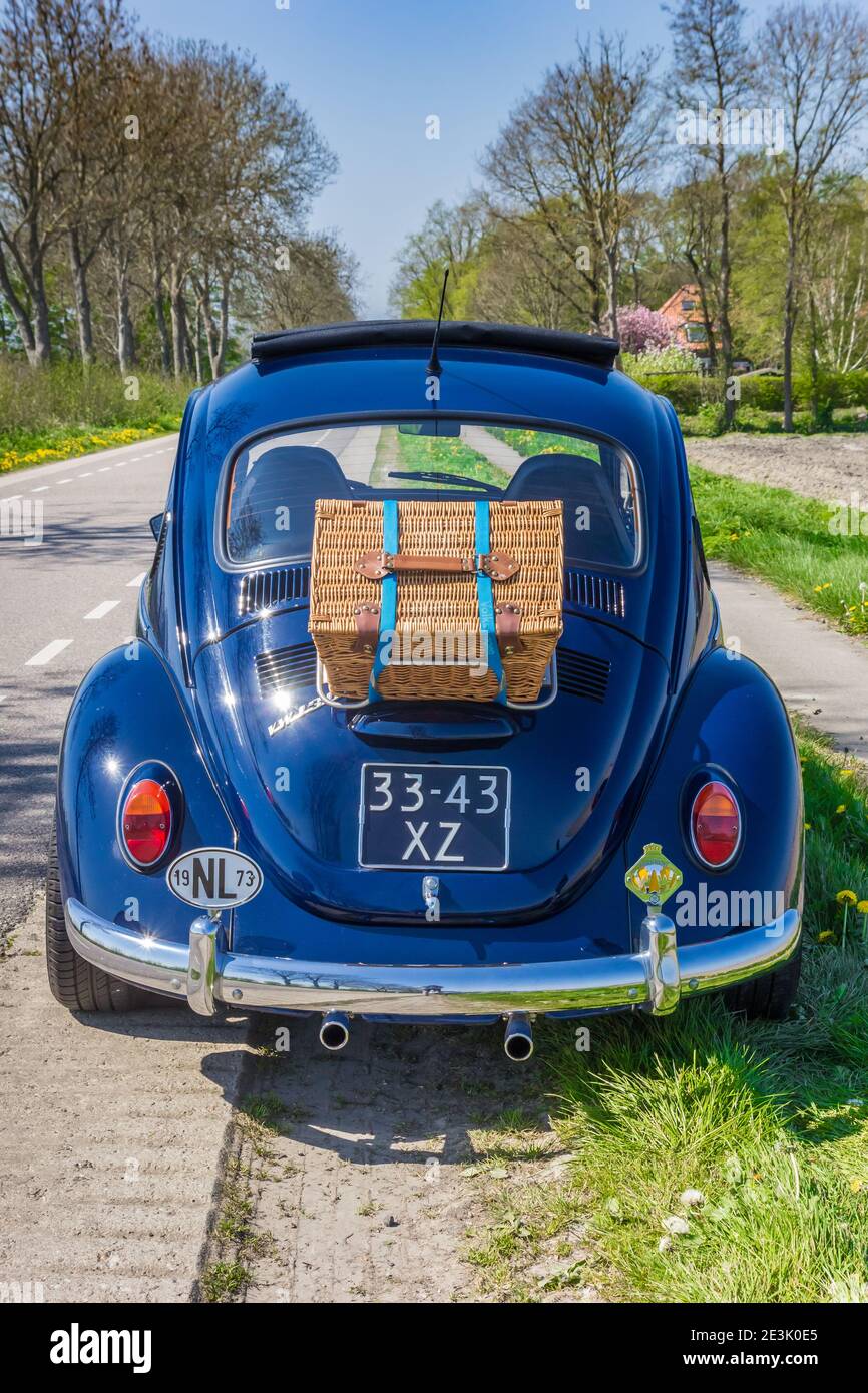 Klassischer blauer Volkswagen Käfer mit einem Picknickkorb auf dem Zurück in den Niederlanden Stockfoto