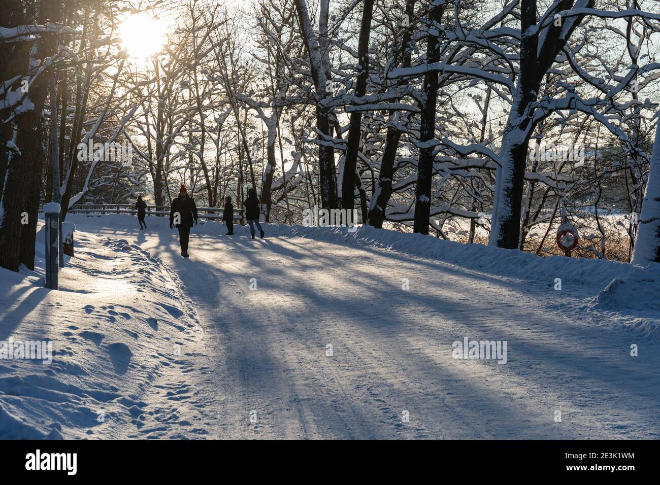 Menschen, die an einem sonnigen Wintertag im Stadtteil Linnunlaulu in Helsinki, Finnland, spazieren gehen Stockfoto