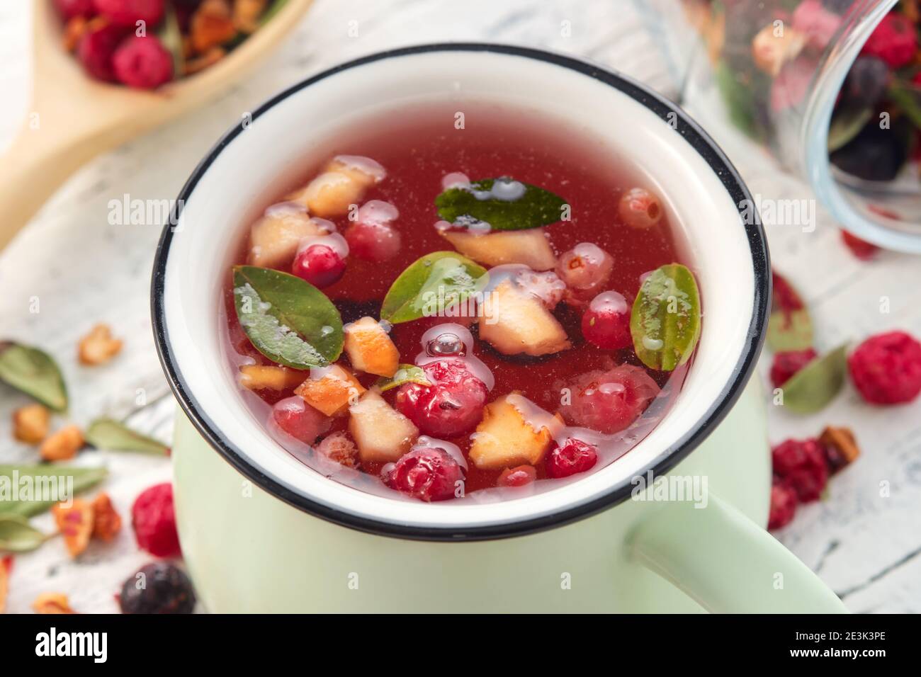 Tasse gesunden Früchtetee mit Äpfeln, Orange, Rot und Schwarz Johannisbeeren. Stockfoto