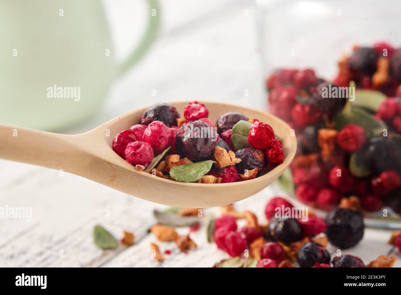 Holzlöffel Früchtetee mit Äpfeln, Orangen, roten und schwarzen Johannisbeeren. Glas gesunden Früchtetee auf dem Hintergrund. Stockfoto
