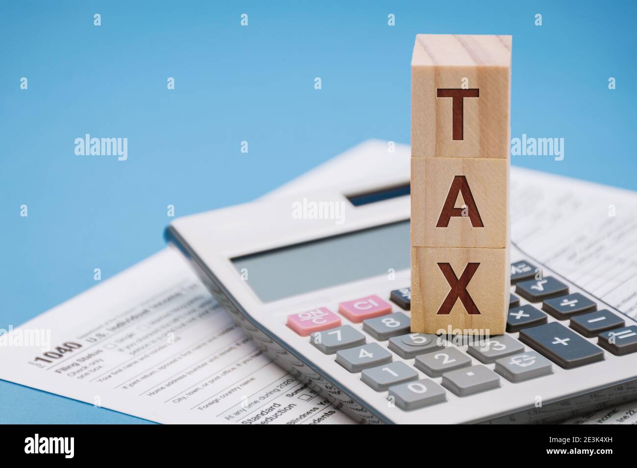 Steuerwort auf Holzblock oben auf Rechner ein Hellblauer Hintergrund Stockfoto