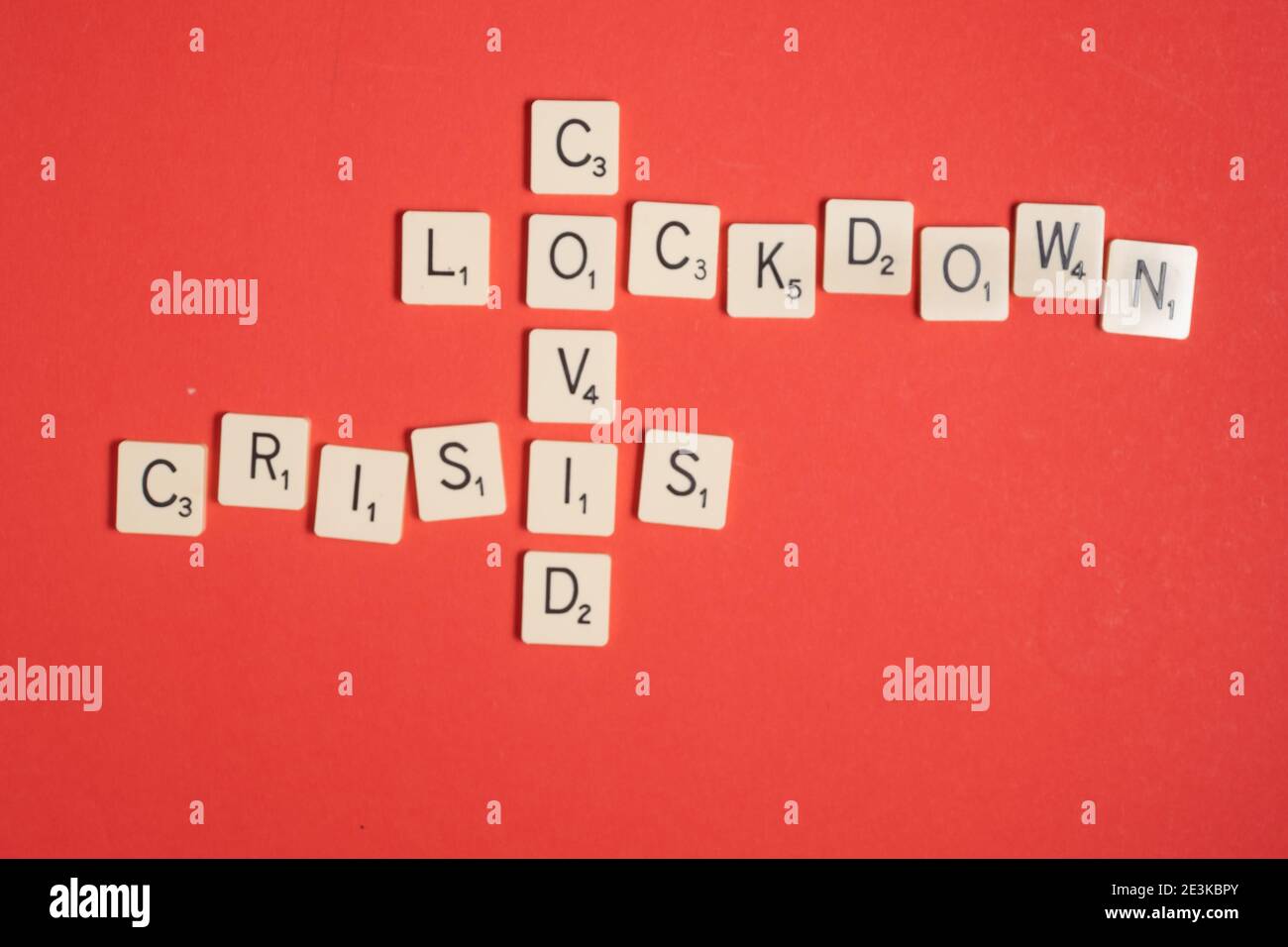 Covid-Krise. Kreuzworträtsel auf rotem Hintergrund. Speicherplatz kopieren. Konsequenzen von covid-19 Stockfoto