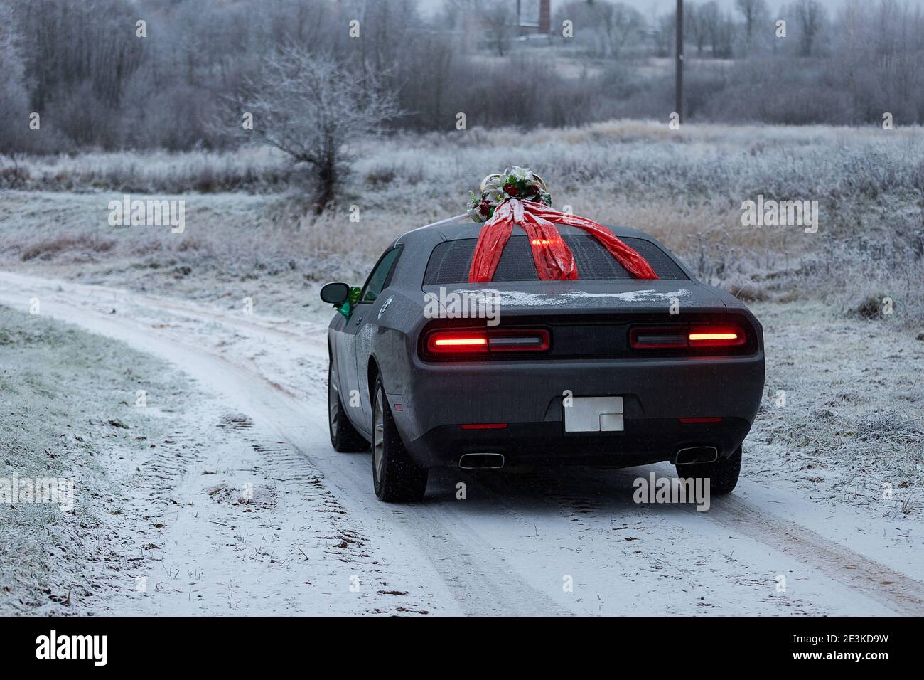 Das Auto fährt auf einer winterverschneiten Autobahn, schlechte Wetterbedingungen und rutschiger Asphalt erfordern vorsichtiges Fahren und niedrige Geschwindigkeit für die Sicherheit Stockfoto