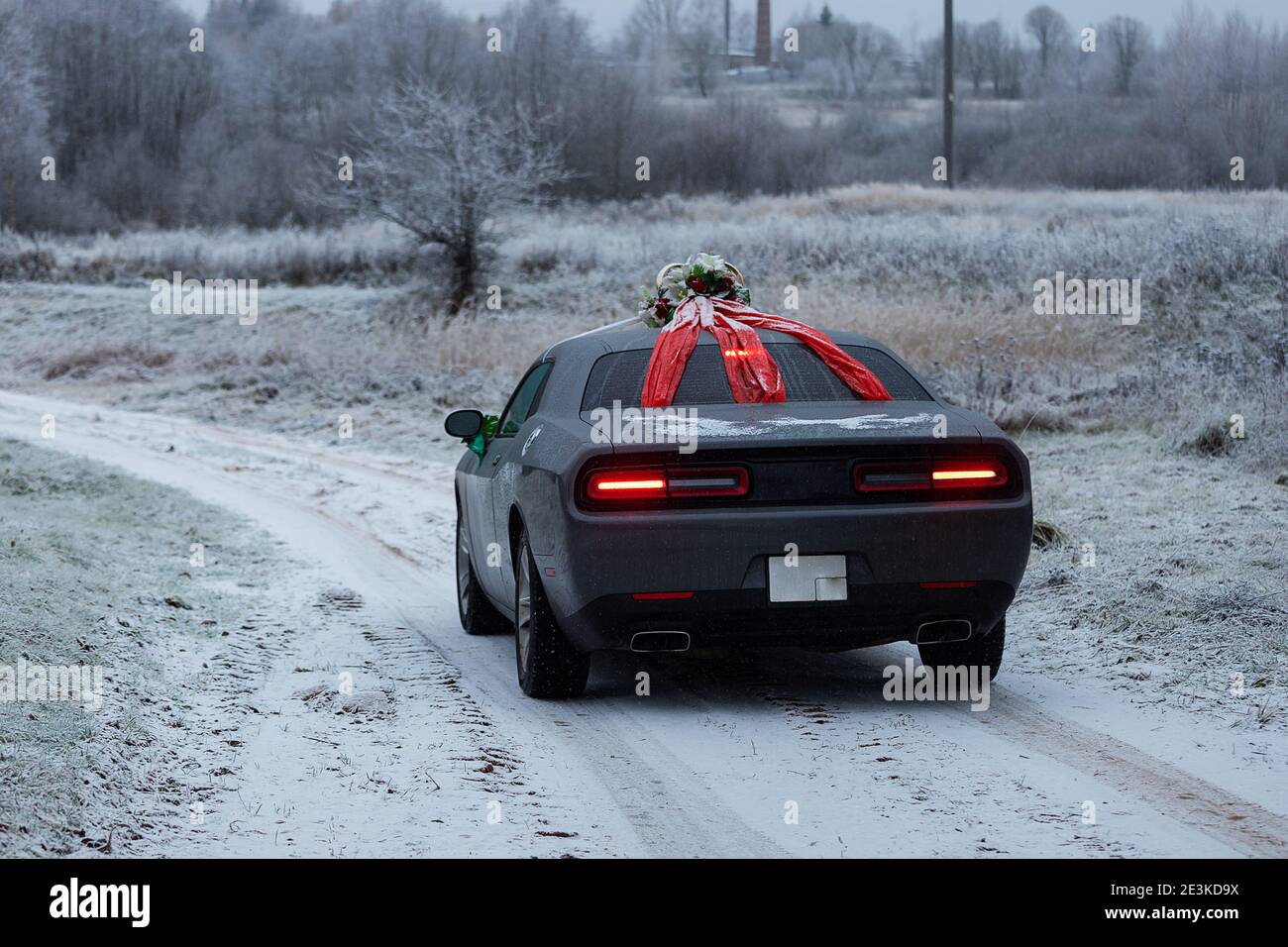 Das Auto fährt auf einer winterverschneiten Autobahn, schlechte Wetterbedingungen und rutschiger Asphalt erfordern vorsichtiges Fahren und niedrige Geschwindigkeit für die Sicherheit Stockfoto