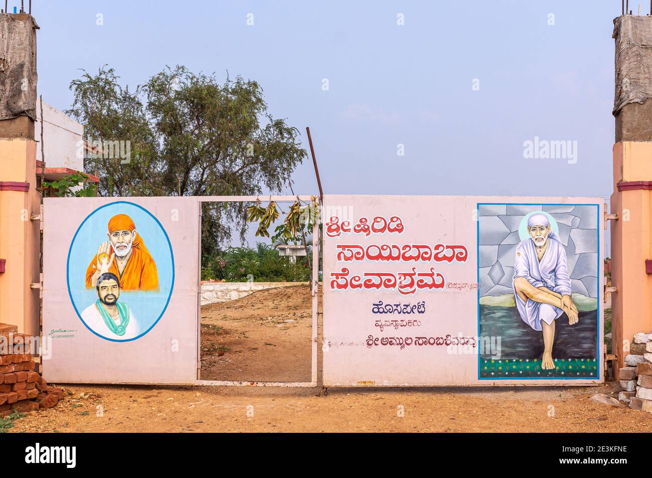 Hampi, Karnataka, Indien - 5. November 2013: Eingangstor zu Shree Shirdi Saibaba Sevashram ist ein Metallhafen mit Farbbildern von Original und Contempo Stockfoto