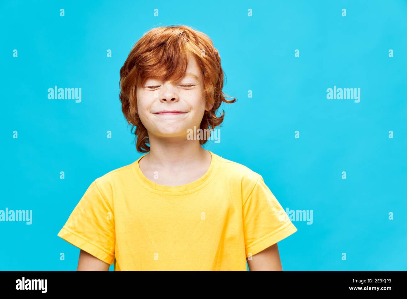 Heiter Rotschopf junge vermasselt seine Augen Lächeln Studio gelb t-Shirt Stockfoto