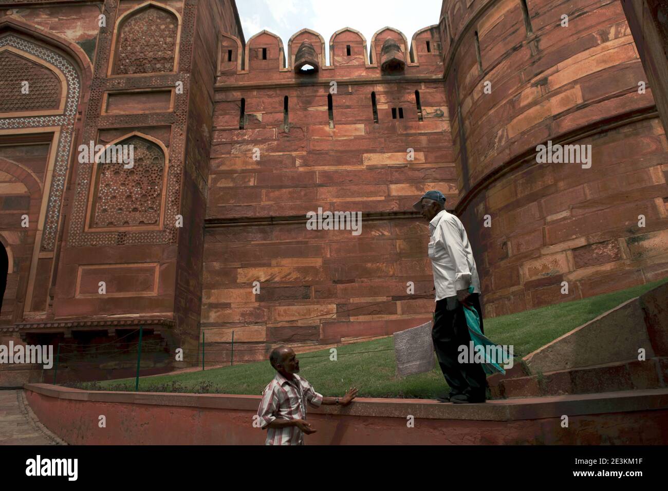 Männer, die auf dem Rasen vor dem Amar Singh Gate von Agra Fort in Agra, Uttar Pradesh, Indien, sprechen. Stockfoto