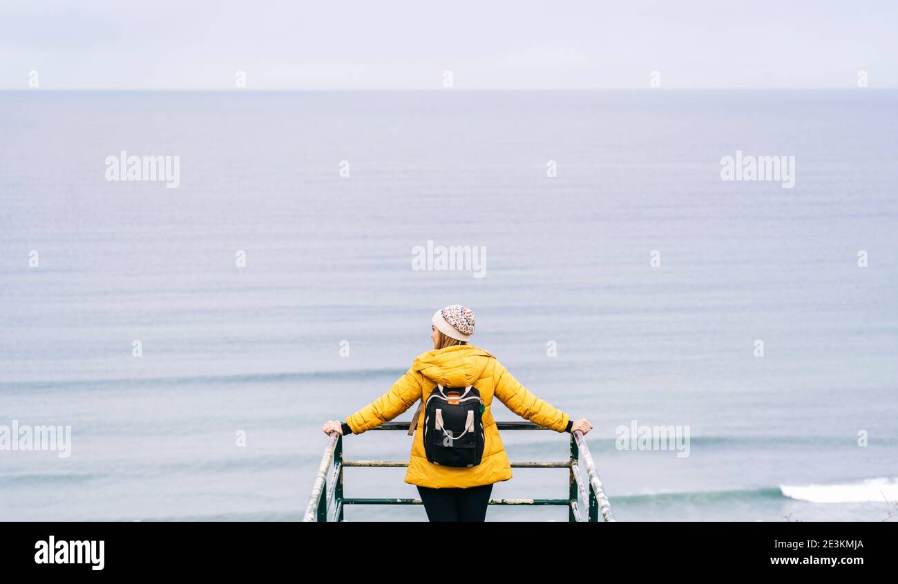 Eine Frau, die von hinten auf das Meer schaut Stockfoto