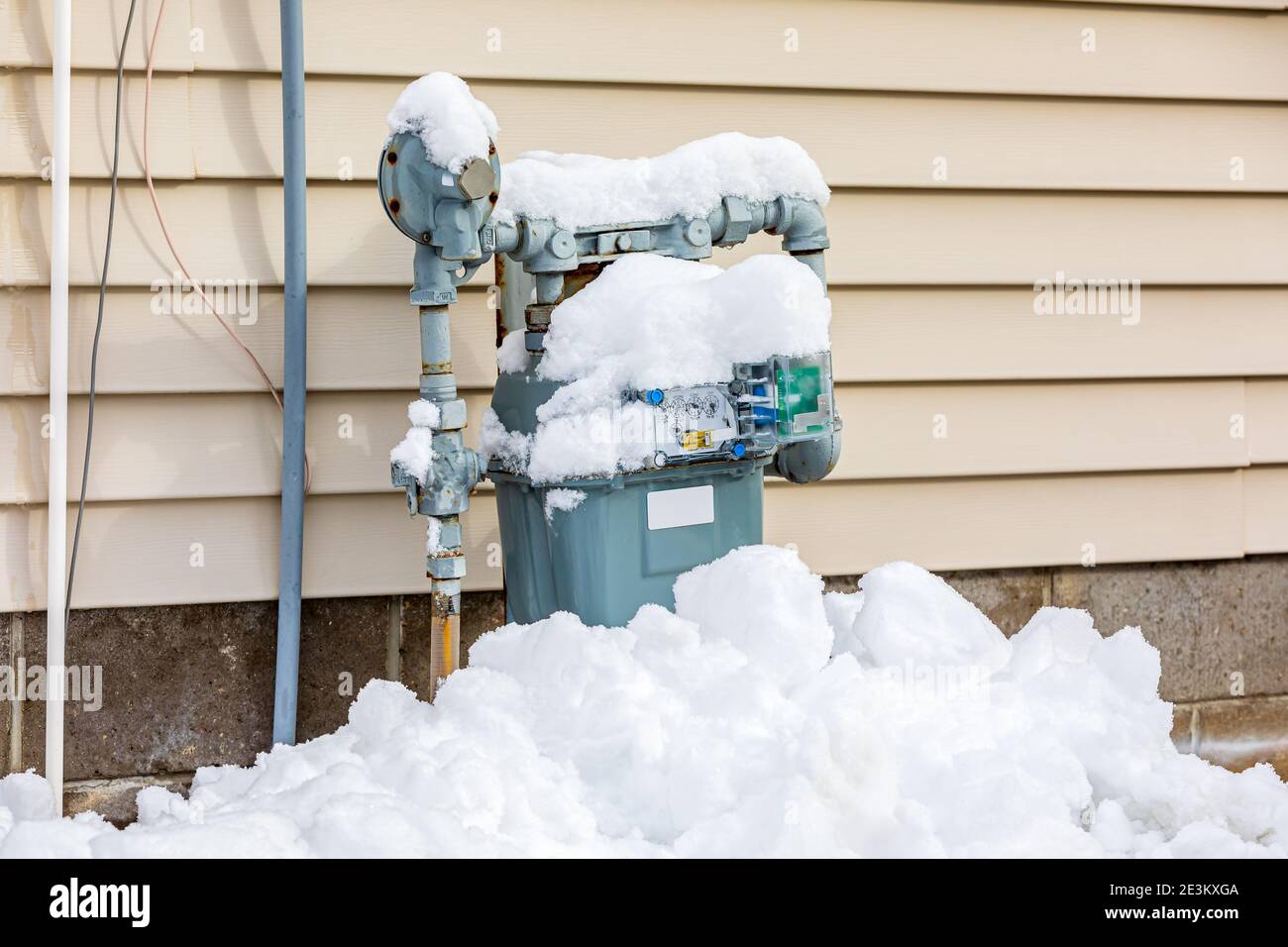 Erdgaszähler im Winter mit Schnee bedeckt. Konzept der Energieeinsparung, Heizkosten für Wohngebäude und Erdgasproduktion Stockfoto