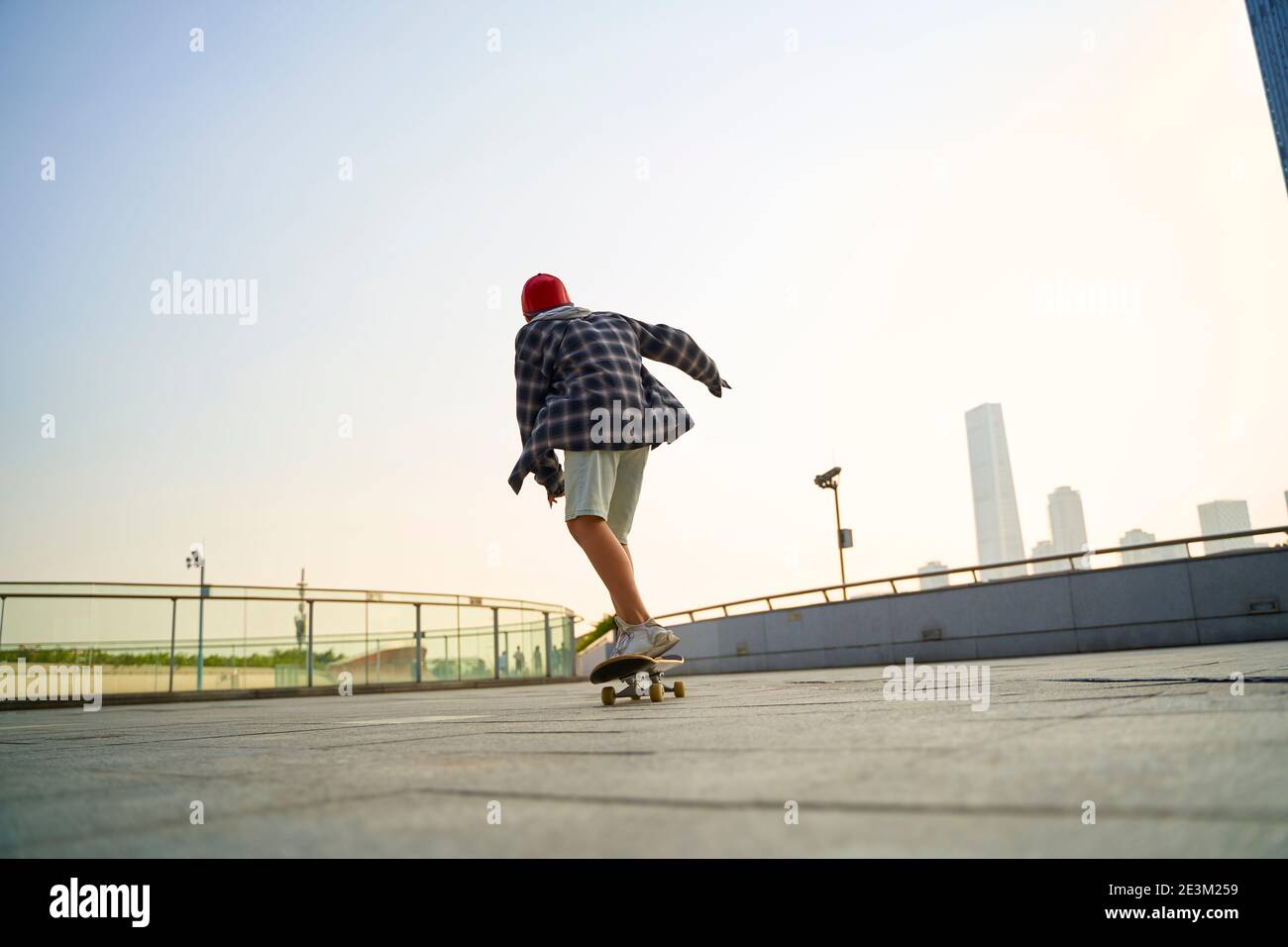 Teenager asiatische Kind Skateboarding im Freien auf einer Fußgängerbrücke Stockfoto