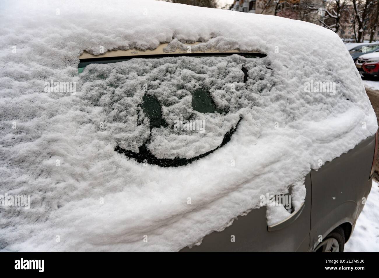 Gezeichnetes Lächeln auf Autoglas auf Schnee Stockfoto