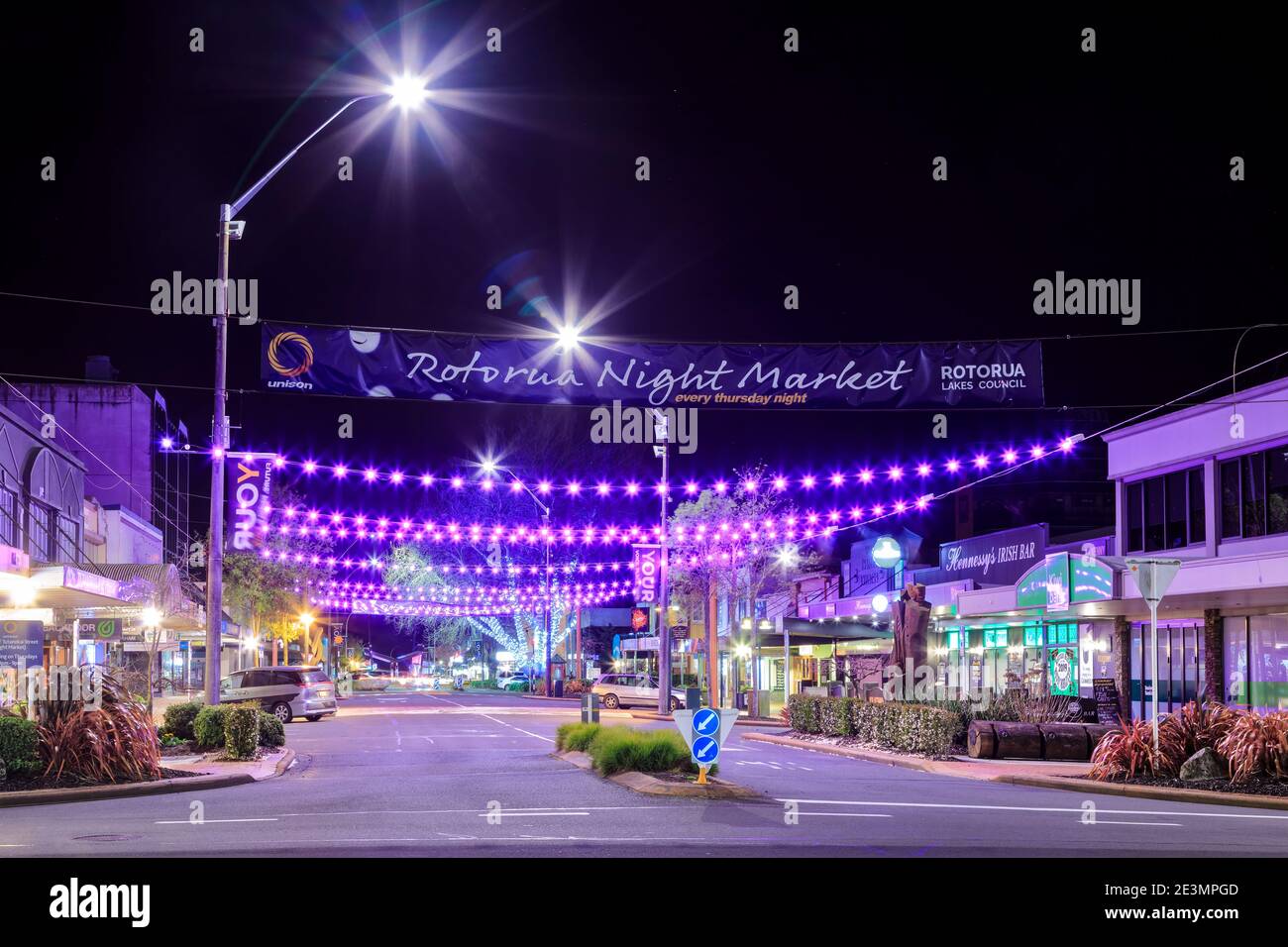 Rotorua, Neuseeland, bei Nacht. Über der Tutanekai Straße hängt eine farbenfrohe Beleuchtung und ein Banner, das den Nachtmarkt der Stadt ankündigt Stockfoto