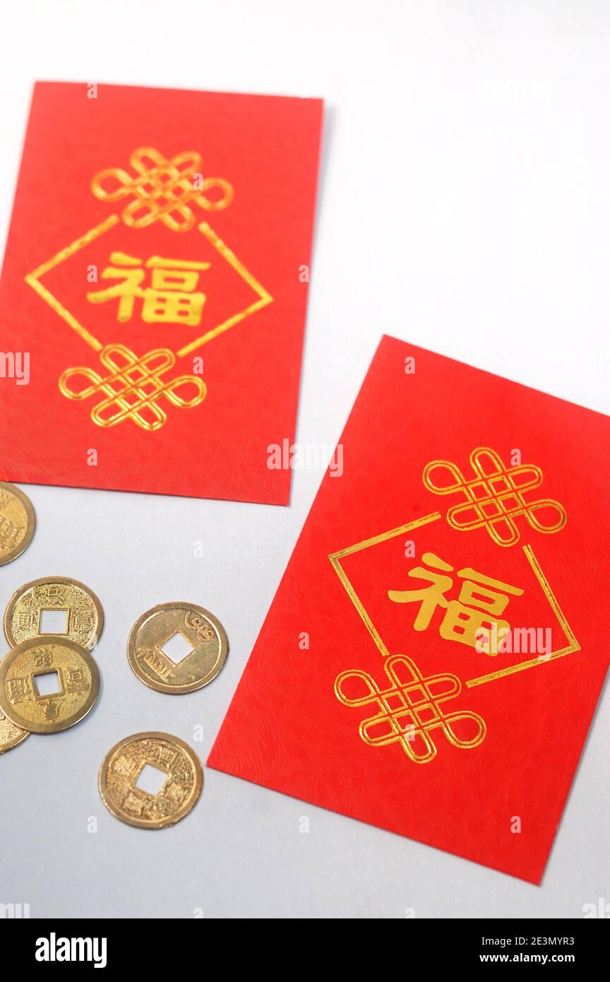 Roter Umschlag namens "Ang Pao" und Goldmünzen in chinesischen Neujahrskonzept, Sparkonzept und Reichtum. Stockfoto