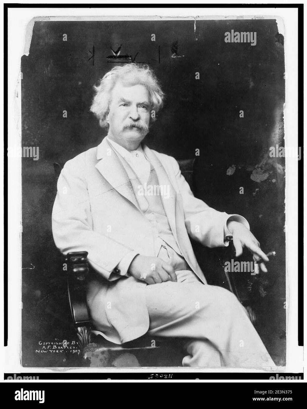 Mark Twain, dreiviertel langes Porträt, sitzend, leicht nach rechts ausgerichtet, mit Zigarre in der Hand Stockfoto