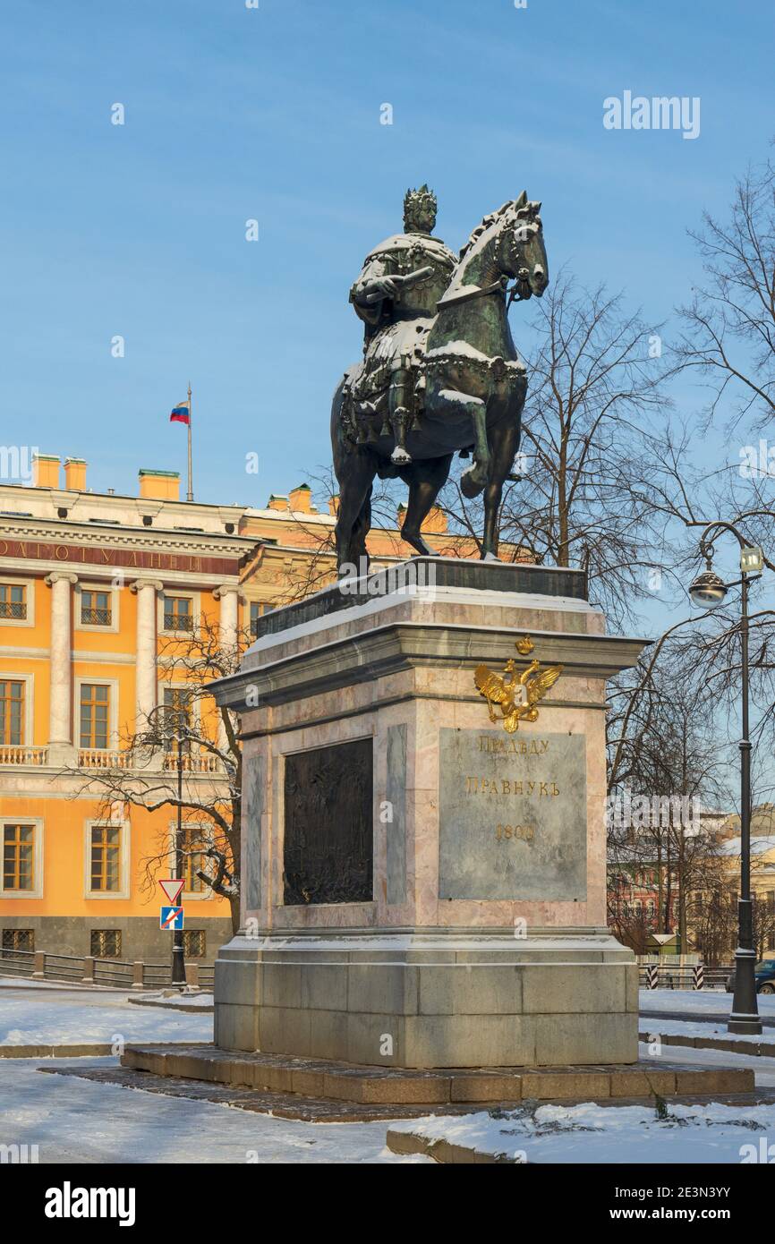 Sankt Petersburg, Russland - 16. Januar 2021: Statue von Peter dem Großen auf einem Sockel vor dem Mikhailowski Schloss mit der russischen Flagge in wint Stockfoto