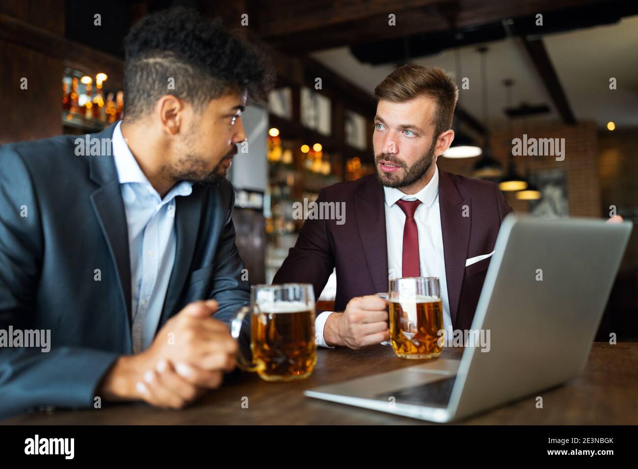 Selbstbewusste Geschäftsleute, die in einem Restaurant miteinander reden und arbeiten Stockfoto