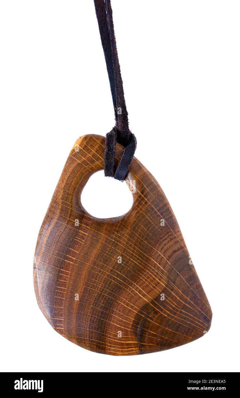 Hausgemachtes Amulett ist aus Massivholz gefertigt und hängt an einem Lederseil. Isoliertes Makro Stockfoto