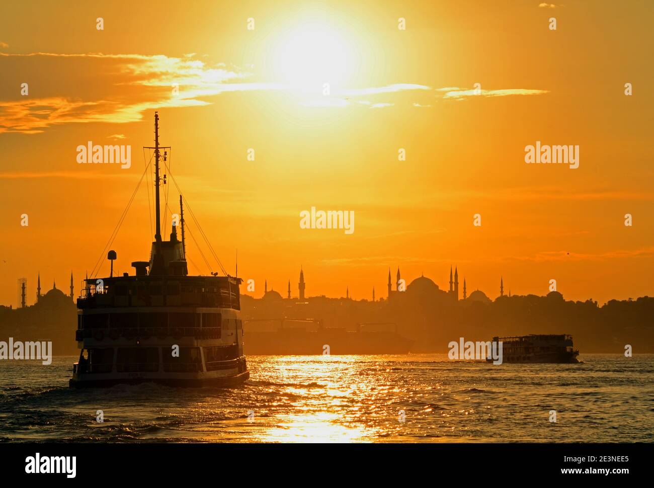 Sonnenuntergang in Istanbul, wunderbares goldenes Licht, wenn Fähren die Passagiere in die Altstadt mit der Blauen Moschee in der Ferne bringen. Stockfoto