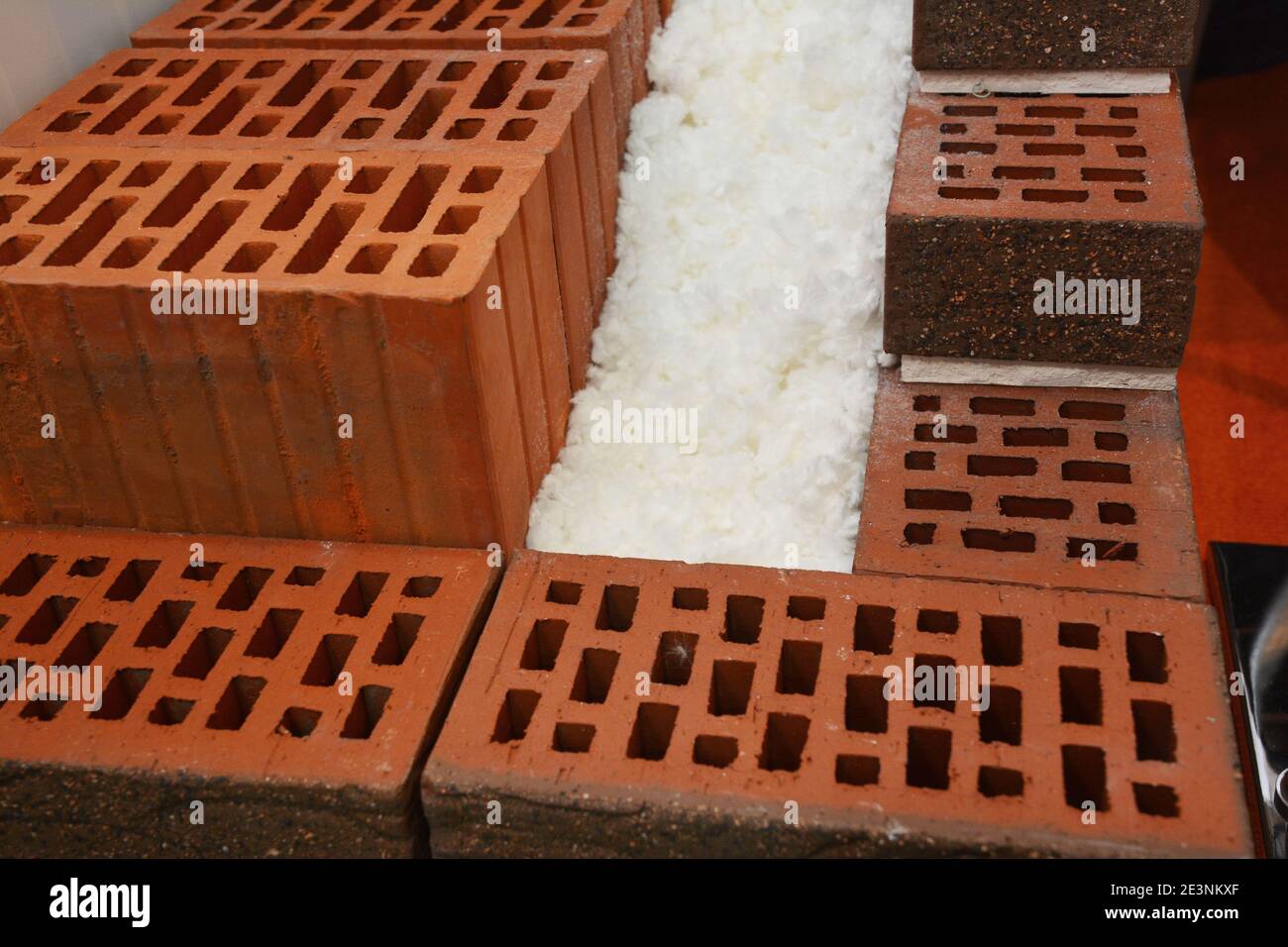 Nahaufnahme eines Querschnitts einer unfertigen energieeffizienten, wärmegedämmten Hauswand aus porösen Keramikblöcken und Polystyrol. Stockfoto