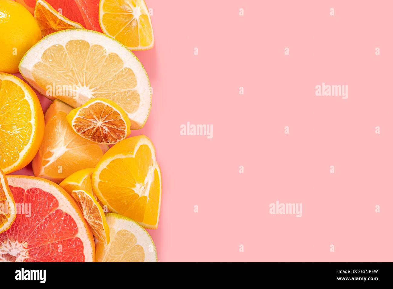 Scheiben von Orange, rosa Grapefruit und Zitronenfrüchten auf rosa Hintergrund. Minimale Zusammensetzung. Rahmen für Obstgerichte. Gesunde Ernährung und Ernährung. Draufsicht flach l Stockfoto