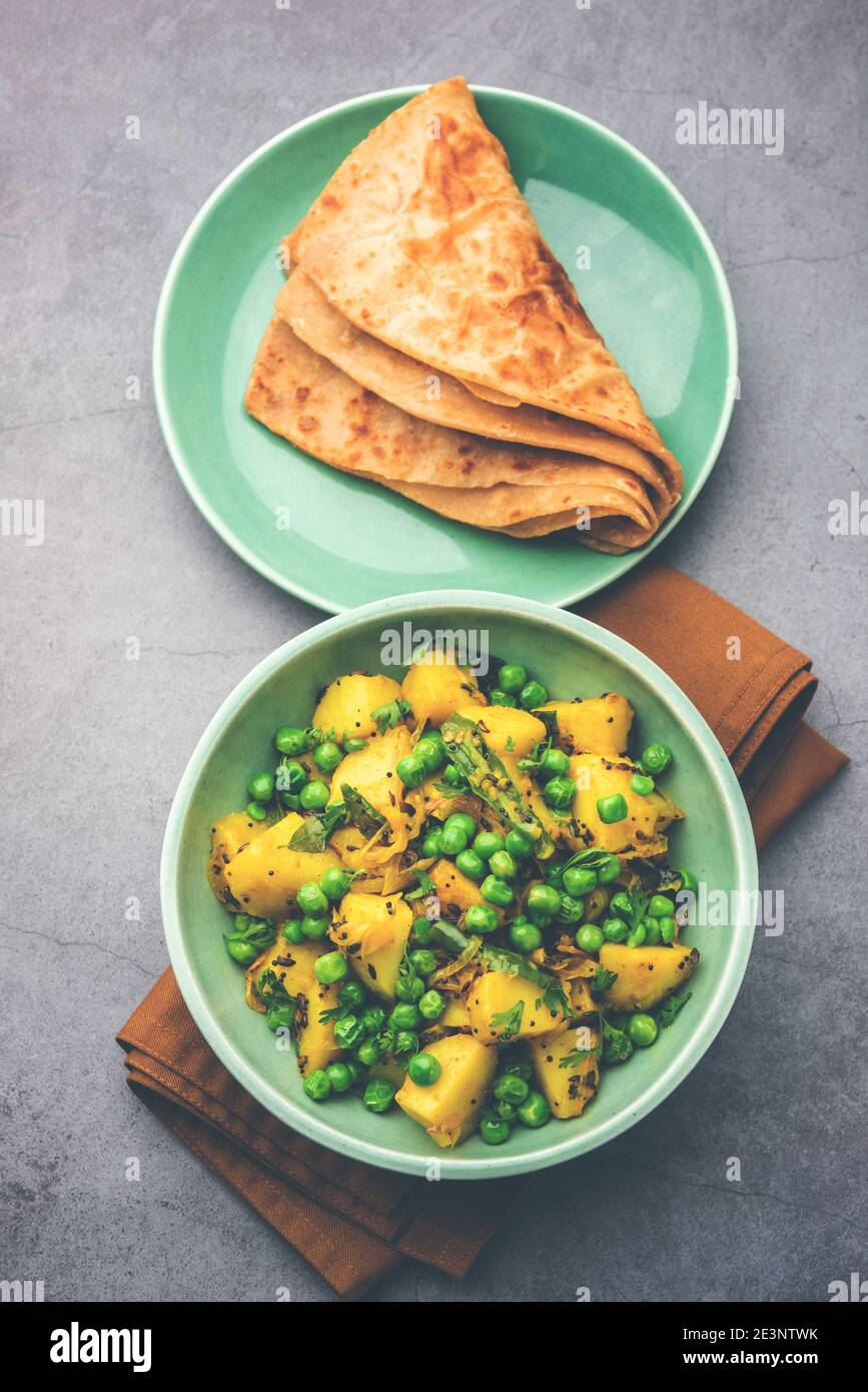 Aloo Mutter oder Matar aalu trocken Sabzi, Indische Kartoffel und grünen Erbsen gebraten zusammen mit Gewürzen und garniert mit Korianderblättern. Serviert mit Roti oder Stockfoto