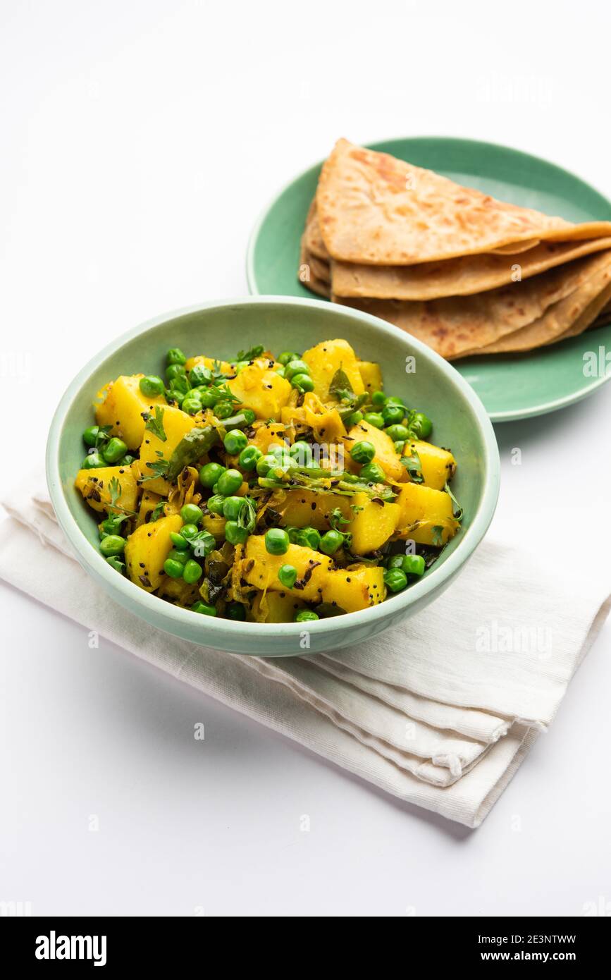 Aloo Mutter oder Matar aalu trocken Sabzi, Indische Kartoffel und grünen Erbsen gebraten zusammen mit Gewürzen und garniert mit Korianderblättern. Serviert mit Roti oder Stockfoto
