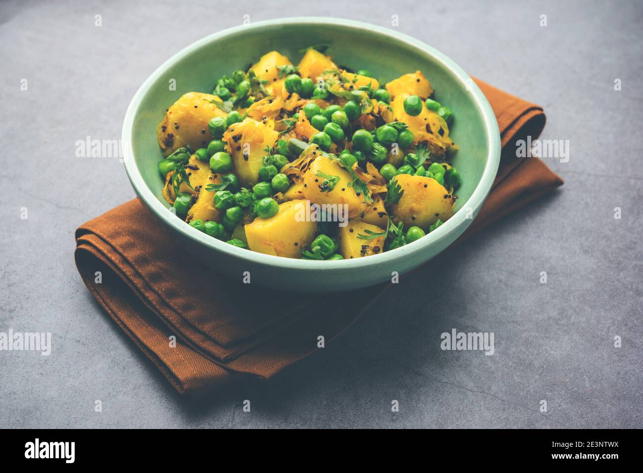 Aloo Mutter oder Matar aalu trocken Sabzi, Indische Kartoffel und grünen Erbsen gebraten zusammen mit Gewürzen und garniert mit Korianderblättern. Serviert mit Roti oder Stockfoto