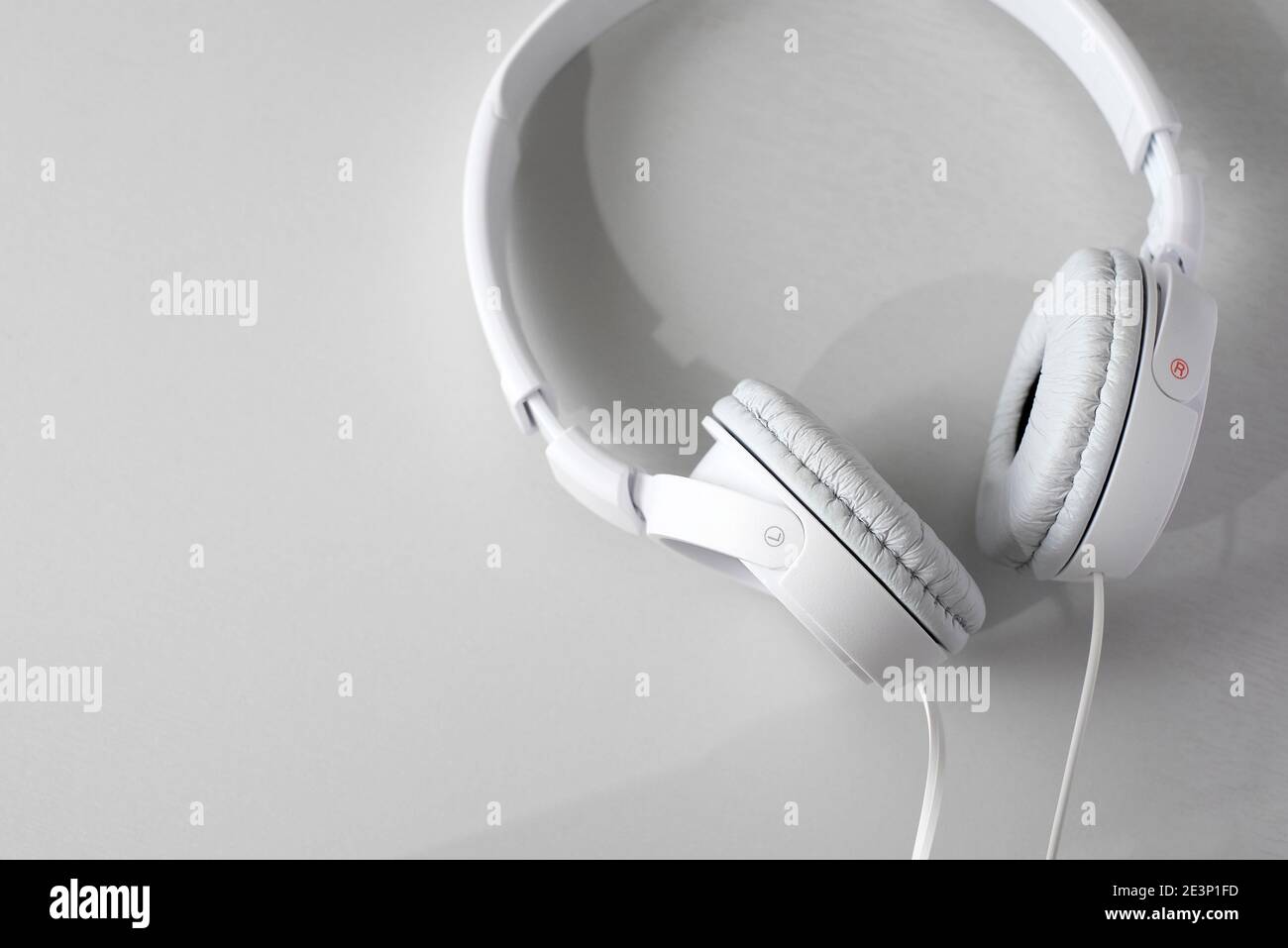 Weiße Kopfhörer auf hellgrauem Hintergrund Stockfoto