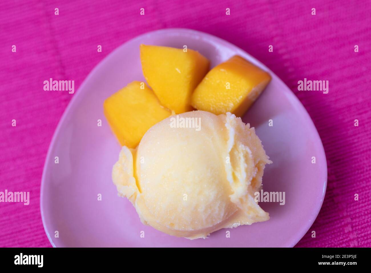 Kugel Mango-Eis von oben mit frischer Mango Stücke auf einem Teller Stockfoto