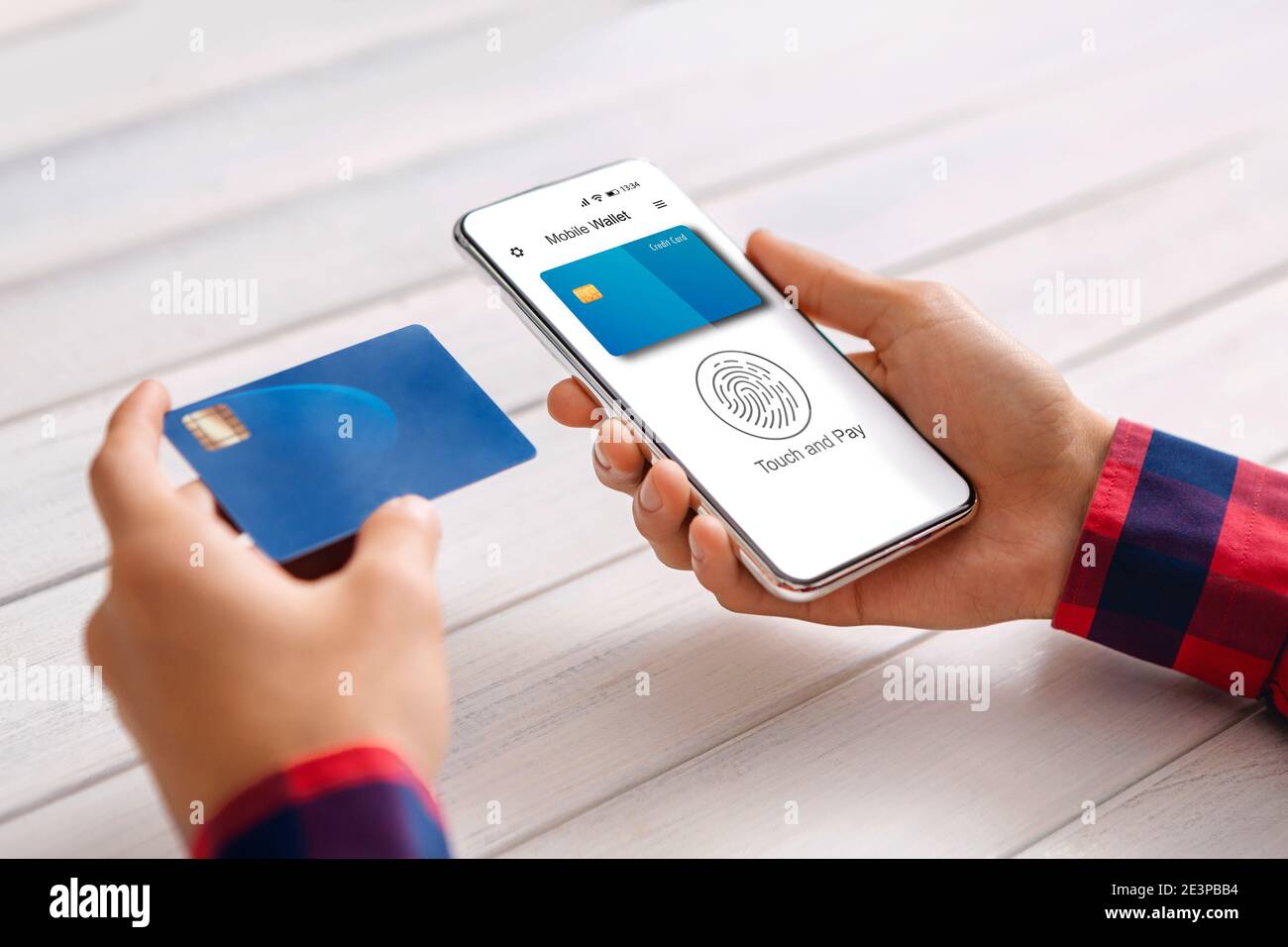 Typ, der Telefon und Kreditkarte benutzt und mit E-Wallet innerhalb bezahlt Stockfoto