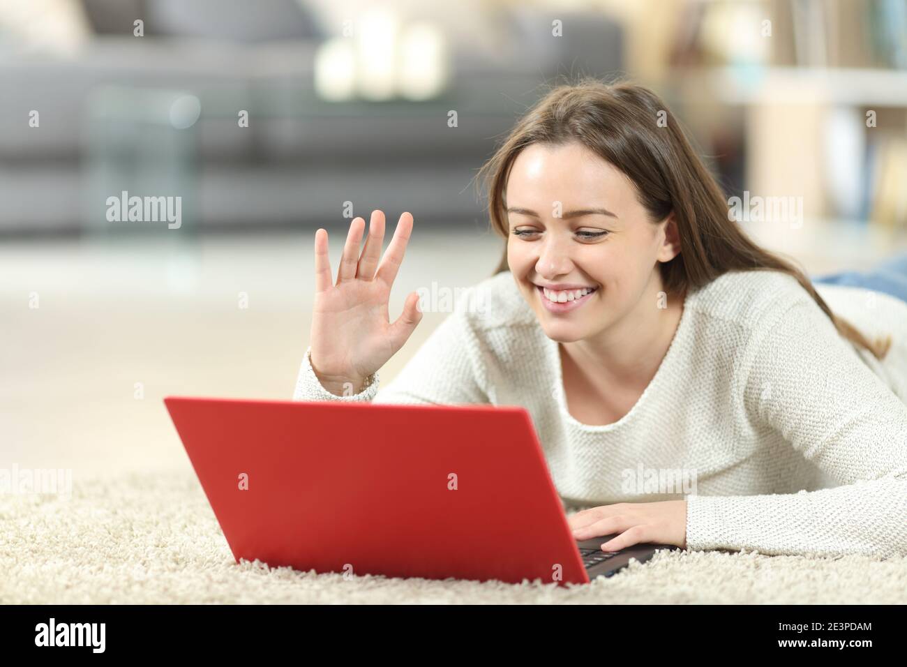 Happy teen Videocalling auf Laptop liegend auf dem Boden an Zu Hause Stockfoto