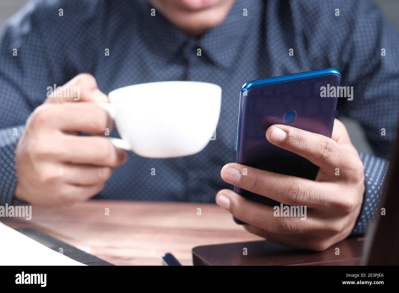 Mann, der von zu Hause aus mit einem Smartphone arbeitet Stockfoto