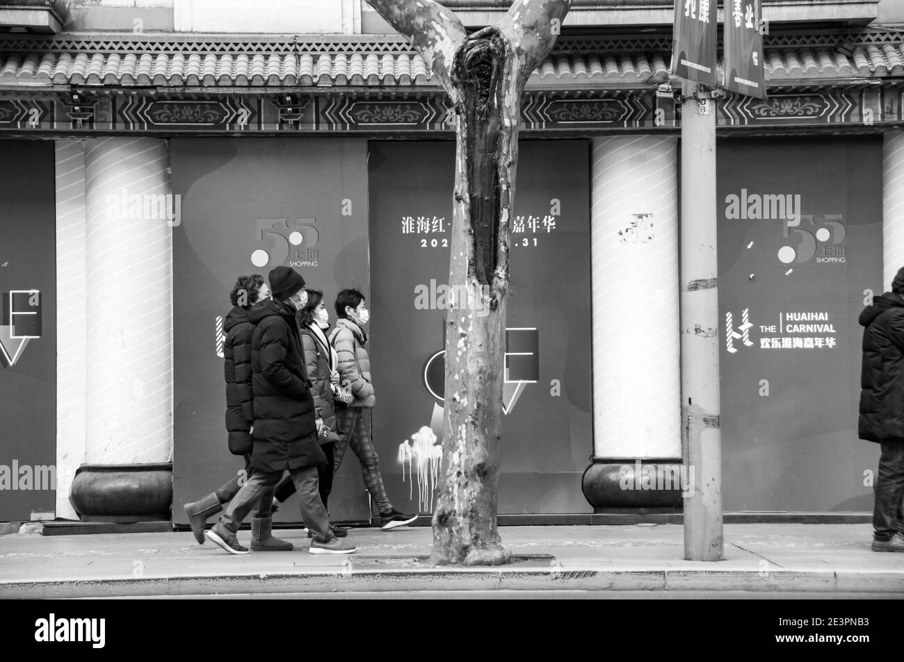 Die Einkäufer kommen an einem Schild für den Huaihai Karneval in der zentralen Huai Hai Road, einer der Haupteinkaufsstraßen in Shanghai, vorbei. Stockfoto