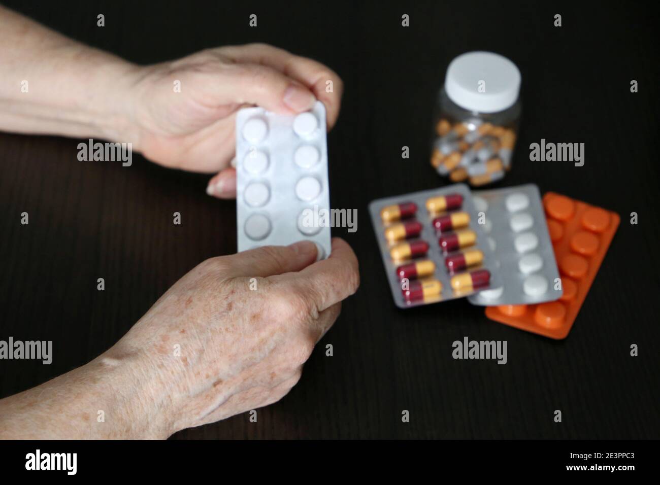 Ältere Frau mit Pillen in faltigen Händen. Verschiedene Medikamente in Tabletten und Kapseln, unter Beruhigungsmittel, Antibiotika oder Vitamine Stockfoto