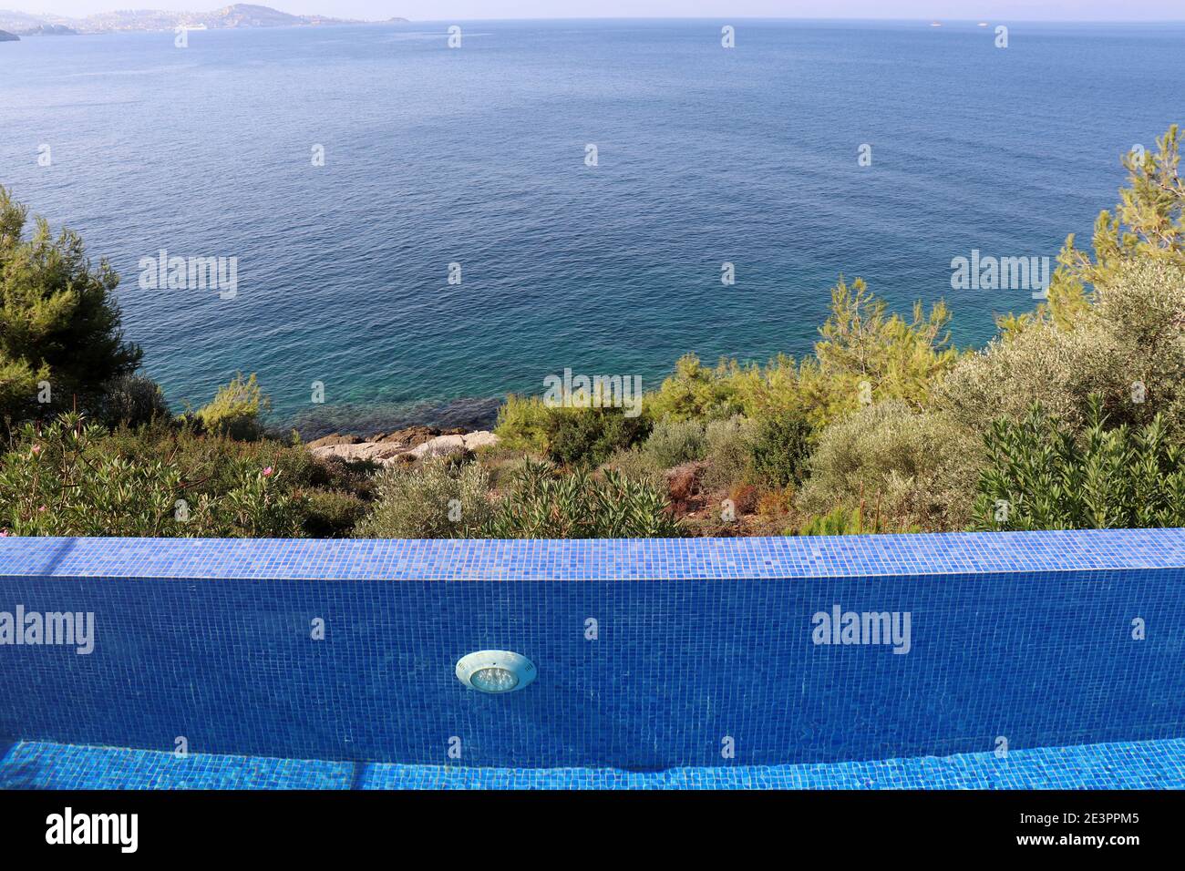 Swimmingpool umgeben von Bäumen auf blauem Meer und Bucht Hintergrund. Strand entspannen und Urlaub, genießen Sie das Lebenskonzept Stockfoto