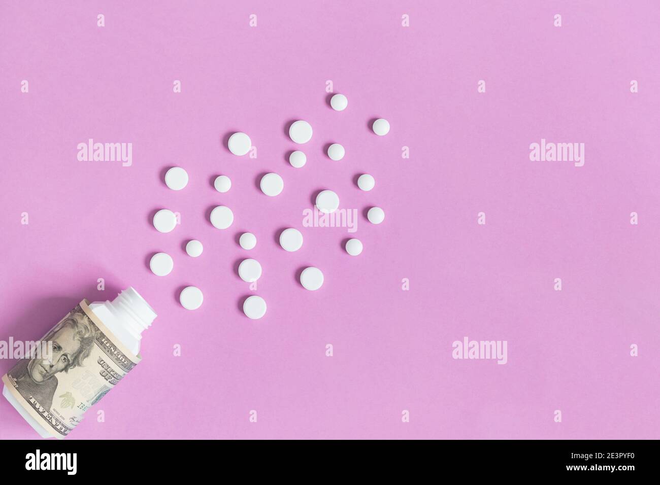 Medizinische Flasche mit Dollar und verschiedenen weißen Pillen. Das Konzept der Versicherungsmedizin, hohe Kosten für Medikamente. Isoliert auf einem rosa Hintergrund. Stockfoto