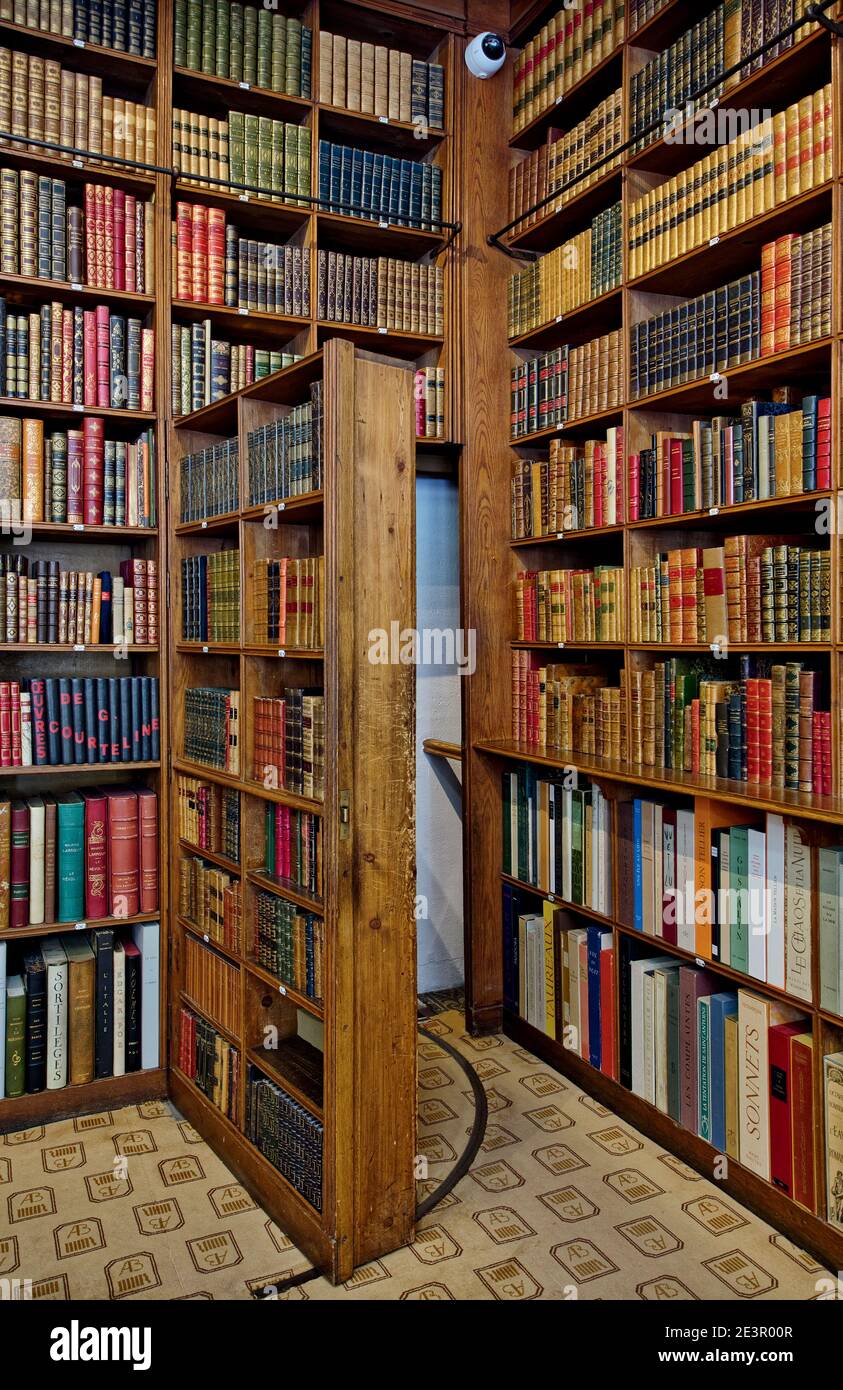 Die geheime Tür des Bücherregals führt zur hinteren Treppe im Antiquariat Auguste Blaizot in Paris, Frankreich. Stockfoto
