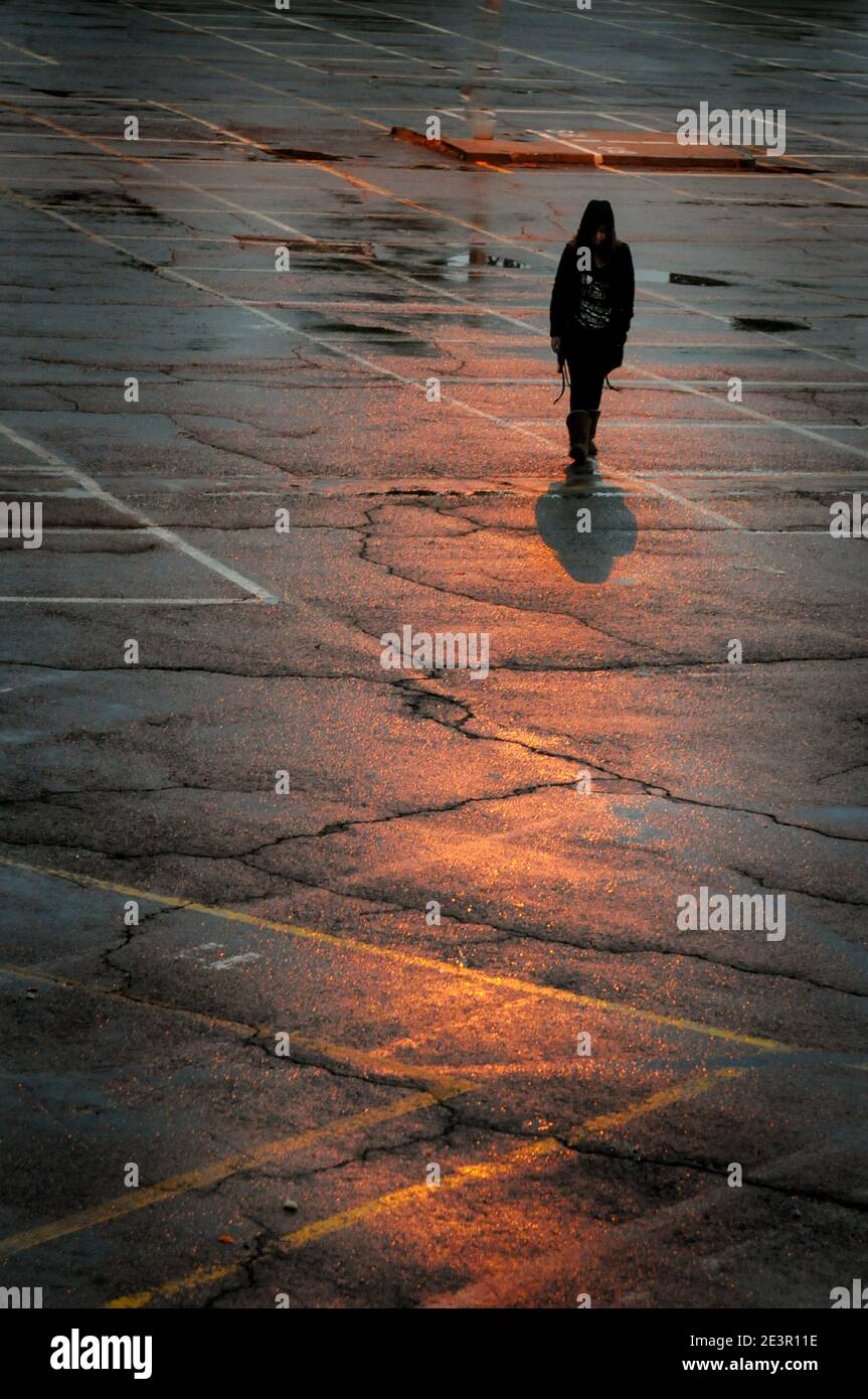 Walking Schatten einer unerkannten Person, die in den Straßen nach Regen Stockfoto