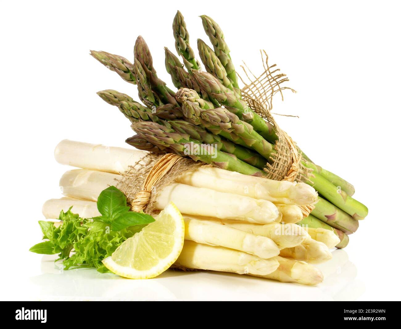 Grün-weiße Asparagus-Bündel mit Lemon auf weißem Hintergrund Stockfoto